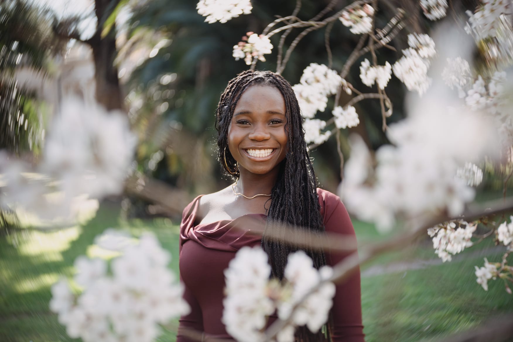 Kim sonriendo entre flores blancas al aire libre